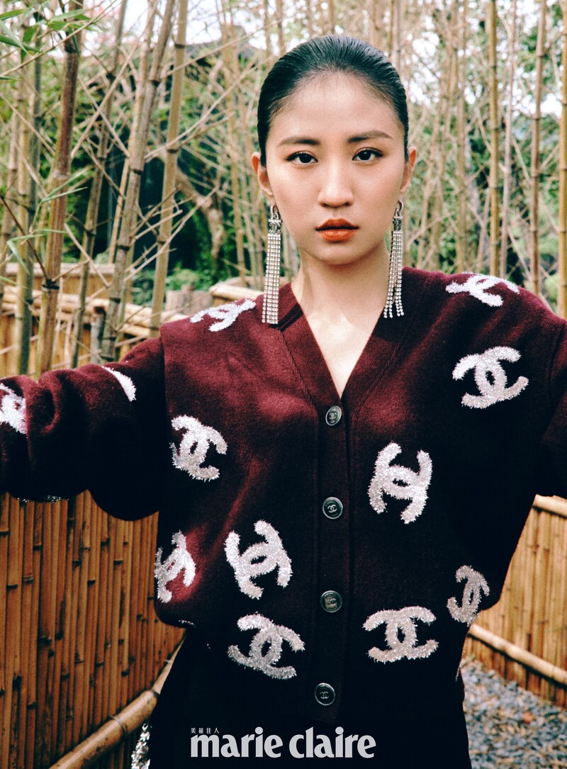 酒紅色刺繡圖紋針織衫、黑色長裙、長耳環、手環,all by Chanel。