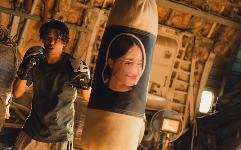 林哲熹在《還錢》中飾演武打擔當，在沙包上貼蔡思韵的照片來練拳