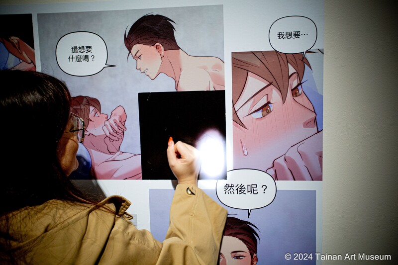 展覽中更安排了《我的室友帥哥學長》互動裝置,觀眾透過手溫感應摩擦黑色圖塊即可看見隱藏版畫面。(南美館提供)