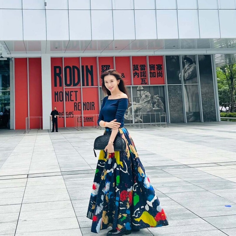林志玲出席富邦美術館展覽,身穿不對稱斜肩藍色上衣搭配彩色印花長裙