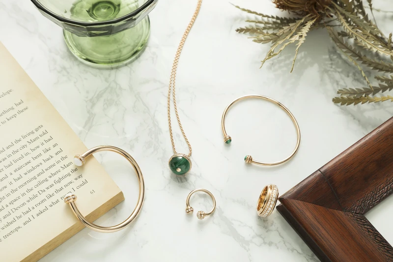 PIAGET Possession系列左至右:白玉髓玫瑰金手鐲、白玉髓玫瑰金戒指、孔雀石玫瑰金項鏈、孔雀石玫瑰金手鐲、18K玫瑰金鑲嵌美鑽戒指。 PIAGET Possession系列左至右:白玉髓玫瑰金手鐲、白玉髓玫瑰金戒指、孔雀石玫瑰金項鏈、孔雀石玫瑰金手鐲、18K玫瑰金鑲嵌美鑽戒指。