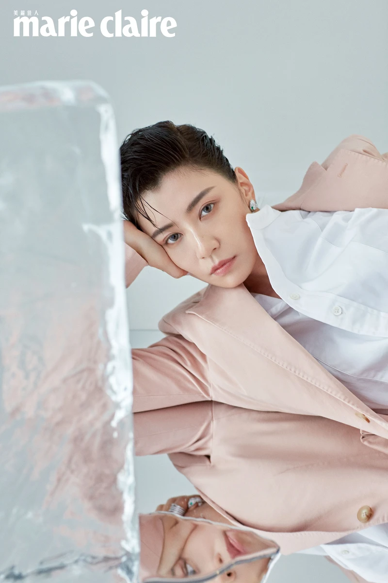 白色襯衫、粉色西裝外套，both by Polo Ralph Lauren；頂級鑽石與祖母綠鑲嵌 Serpenti 耳環，Bulgari。