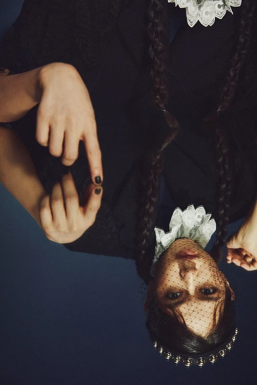 蕾絲披肩、羊毛長大衣,both by Prada;蕾絲裝飾針織衫,Chloé;網紗裝飾髮飾,Red Valentino。 蕾絲披肩、羊毛長大衣,both by Prada;蕾絲裝飾針織衫,Chloé;網紗裝飾髮飾,Red Valentino。