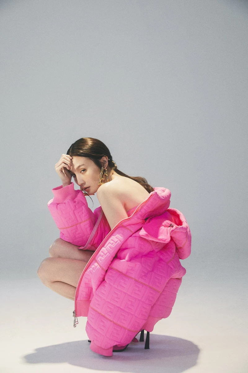 金色雕刻細節雙F字母耳環、螢光桃紅凸紋連帽外套、腰部鏤空單肩泳衣、桃紅色高跟鞋,all by Fendi。 金色雕刻細節雙F字母耳環、螢光桃紅凸紋連帽外套、腰部鏤空單肩泳衣、桃紅色高跟鞋,all by Fendi。