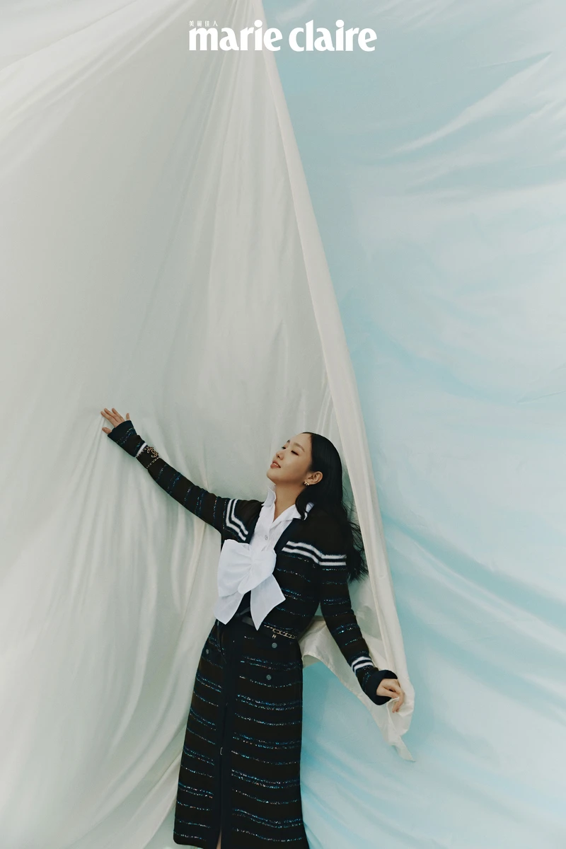 白色褶飾襯衫、白色蝴蝶結短背心、長版針織衫、雙C Logo寬版手鐲、皮穿繩金屬腰帶、Coco Crush 耳環，all by Chanel。