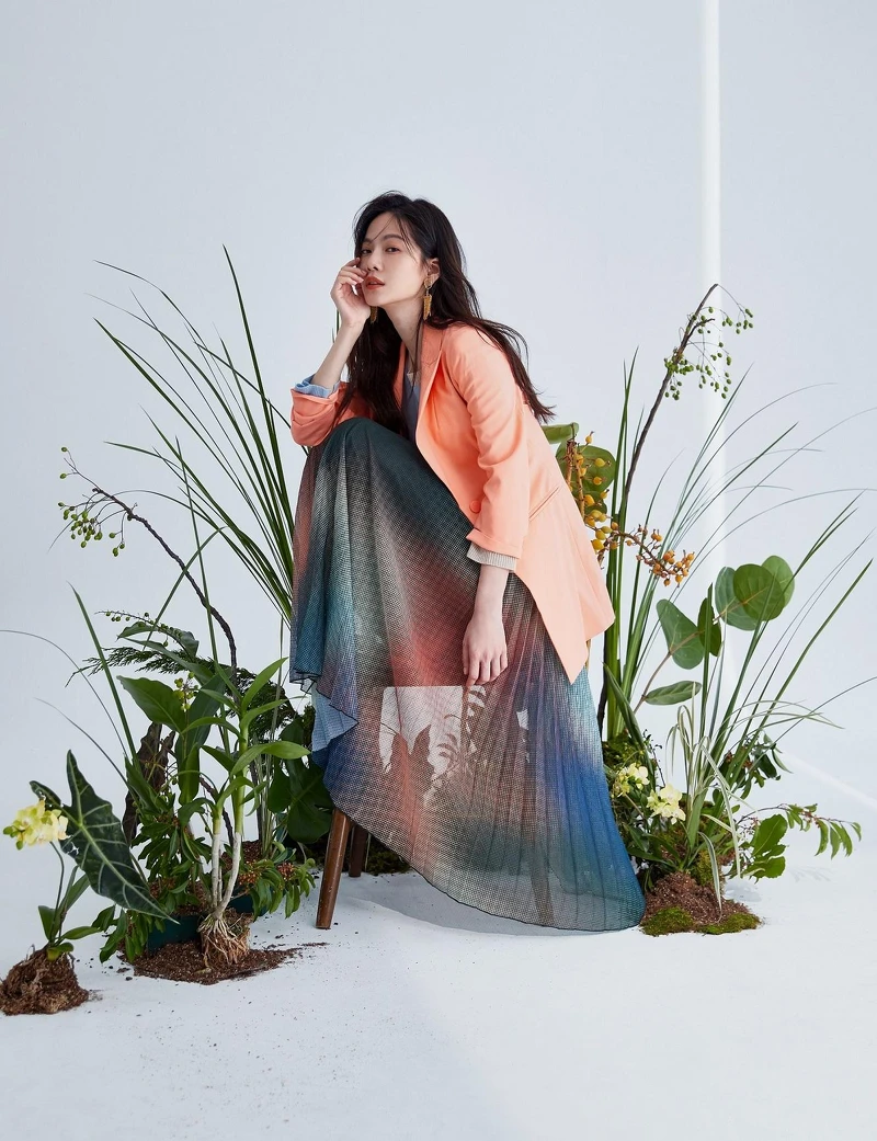 身穿粉橘色套裝與唯美漸層百褶裙,有如在一片綠意盎然中翩然起舞般夢幻。 身穿粉橘色套裝與唯美漸層百褶裙,有如在一片綠意盎然中翩然起舞般夢幻。