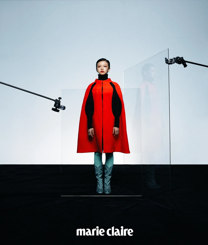 橘紅色斗篷、黑色針織高領、金屬藍長靴，all by Gucci。