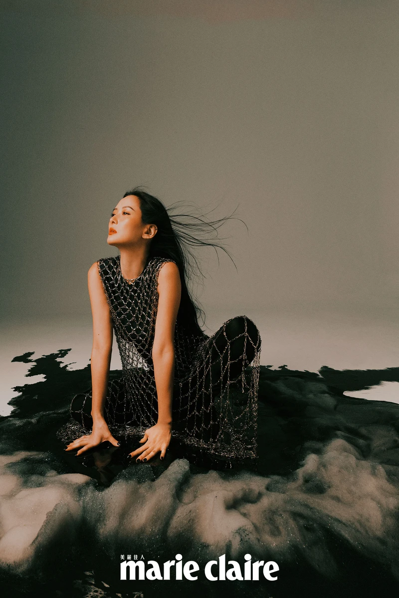 黑色背心、黑色連身鞋褲、水晶鑲嵌網狀罩衫，all by Balenciaga。