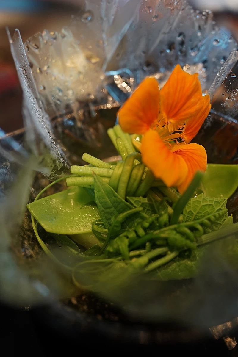 玻璃紙內加入金蓮花、龍鬚菜、山蘇、水蓮跟冬瓜塊。 玻璃紙內加入金蓮花、龍鬚菜、山蘇、水蓮跟冬瓜塊。