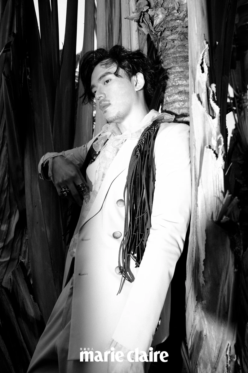 紫色雙排釦西裝外套、粉色長褲，both by BOSS；黑色流蘇胸甲，Vivienne Westwood；藍綠色荷葉邊襯衫，SABRINA HSIEH。