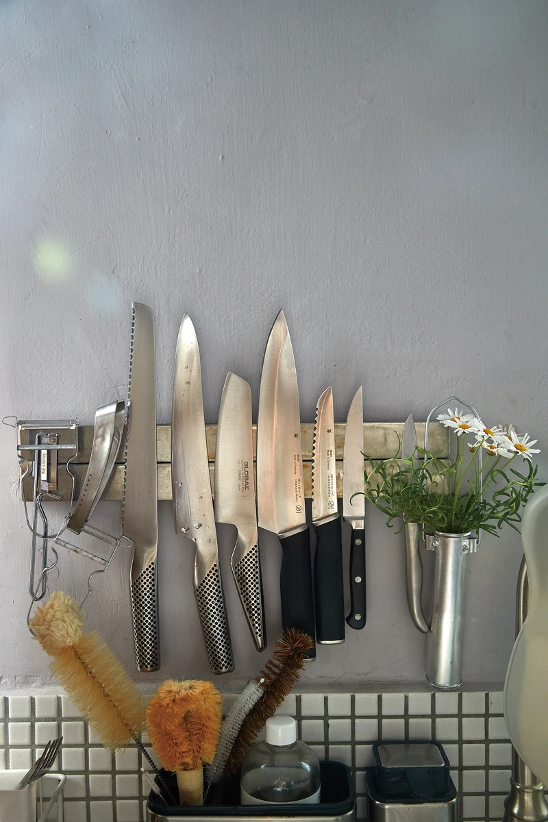 在牆面的刀具就可看出對顏色材質都非常有想法，即便已經是如此漂亮完整的廚房了，還是會細心營造令人愉悅的角落，只需一朵花就可輕易辦到。