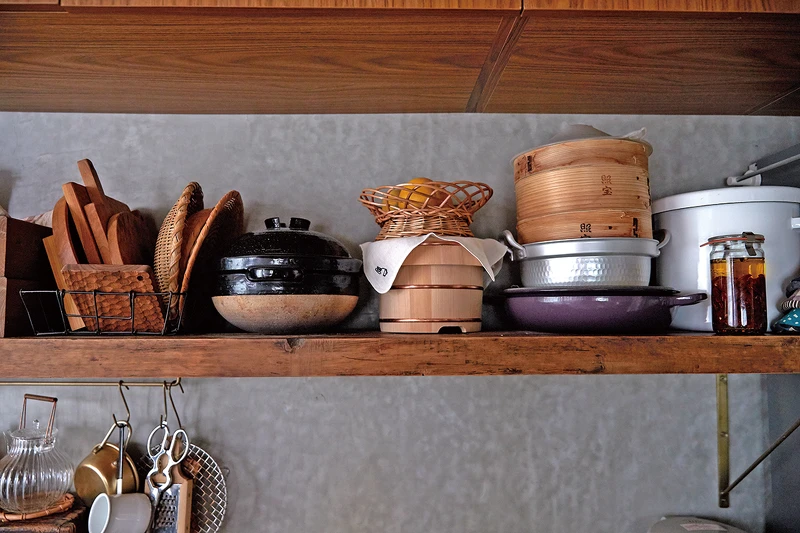 爐台背後是開放式的木頭陳列架，把喜歡的鍋具擺出來，器具顏色也規劃過，木質、玻璃、銅色，看起來不雜亂又有風格。