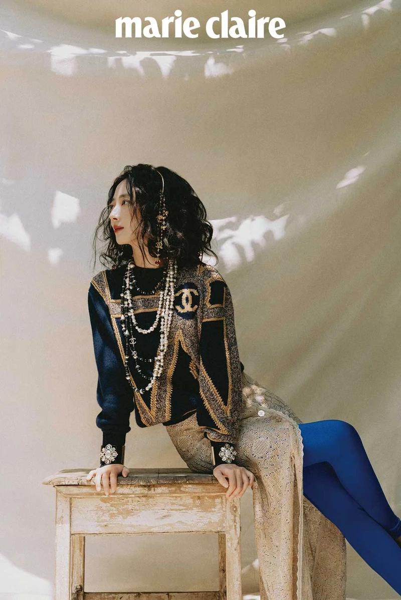 海軍藍金色城堡花園建築風格刺繡毛衣、金色嫘縈開岔長裙、亮藍色 Jersey 針織貼身褲、金屬多彩寶石流蘇造型髮箍、金屬黑白幻象珍珠多層次長項鍊、黑色高級樹脂水晶鑲飾幻象珍珠手環,all by CHANEL。 海軍藍金色城堡花園建築風格刺繡毛衣、金色嫘縈開岔長裙、亮藍色 Jersey 針織貼身褲、金屬多彩寶石流蘇造型髮箍、金屬黑白幻象珍珠多層次長項鍊、黑色高級樹脂水晶鑲飾幻象珍珠手環,all by CHANEL。