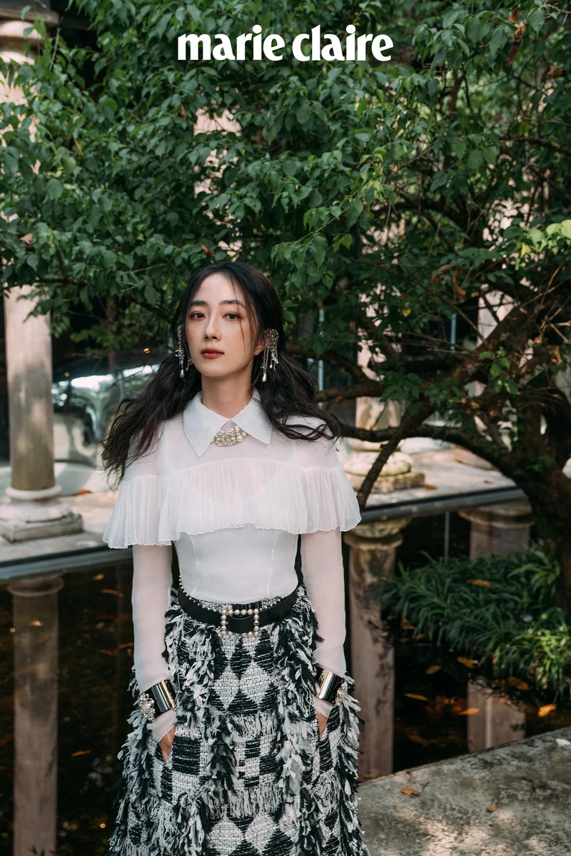 真絲綢紗襯衫飾以褶子荷葉邊與雙C水晶鑲飾鈕扣、黑白格紋斜紋軟呢流蘇長裙、銀色金屬垂墜式幻象珍珠流蘇耳扣、黑色皮革飾以幻象珍珠腰帶、黑色高級樹脂水晶鑲飾幻象珍珠手環、金屬水晶鑲飾雙 C Logo 造型飾以幻象珍珠頸鍊,all by CHANEL。 真絲綢紗襯衫飾以褶子荷葉邊與雙C水晶鑲飾鈕扣、黑白格紋斜紋軟呢流蘇長裙、銀色金屬垂墜式幻象珍珠流蘇耳扣、黑色皮革飾以幻象珍珠腰帶、黑色高級樹脂水晶鑲飾幻象珍珠手環、金屬水晶鑲飾雙 C Logo 造型飾以幻象珍珠頸鍊,all by CHANEL。