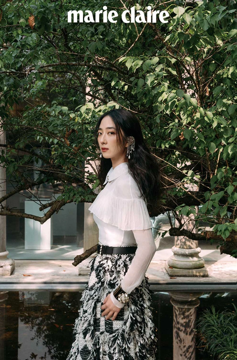 真絲綢紗襯衫飾以褶子荷葉邊與雙C水晶鑲飾鈕扣、黑白格紋斜紋軟呢流蘇長裙、銀色金屬垂墜式幻象珍珠流蘇耳扣、黑色皮革飾以幻象珍珠腰帶、黑色高級樹脂水晶鑲飾幻象珍珠手環、金屬水晶鑲飾雙 C Logo 造型飾以幻象珍珠頸鍊,all by CHANEL。 真絲綢紗襯衫飾以褶子荷葉邊與雙C水晶鑲飾鈕扣、黑白格紋斜紋軟呢流蘇長裙、銀色金屬垂墜式幻象珍珠流蘇耳扣、黑色皮革飾以幻象珍珠腰帶、黑色高級樹脂水晶鑲飾幻象珍珠手環、金屬水晶鑲飾雙 C Logo 造型飾以幻象珍珠頸鍊,all by CHANEL。