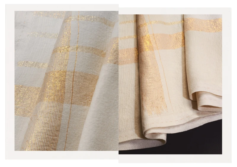 白色喀什米爾羊絨氈與金絲線交織的 Méridien 格紋毯。