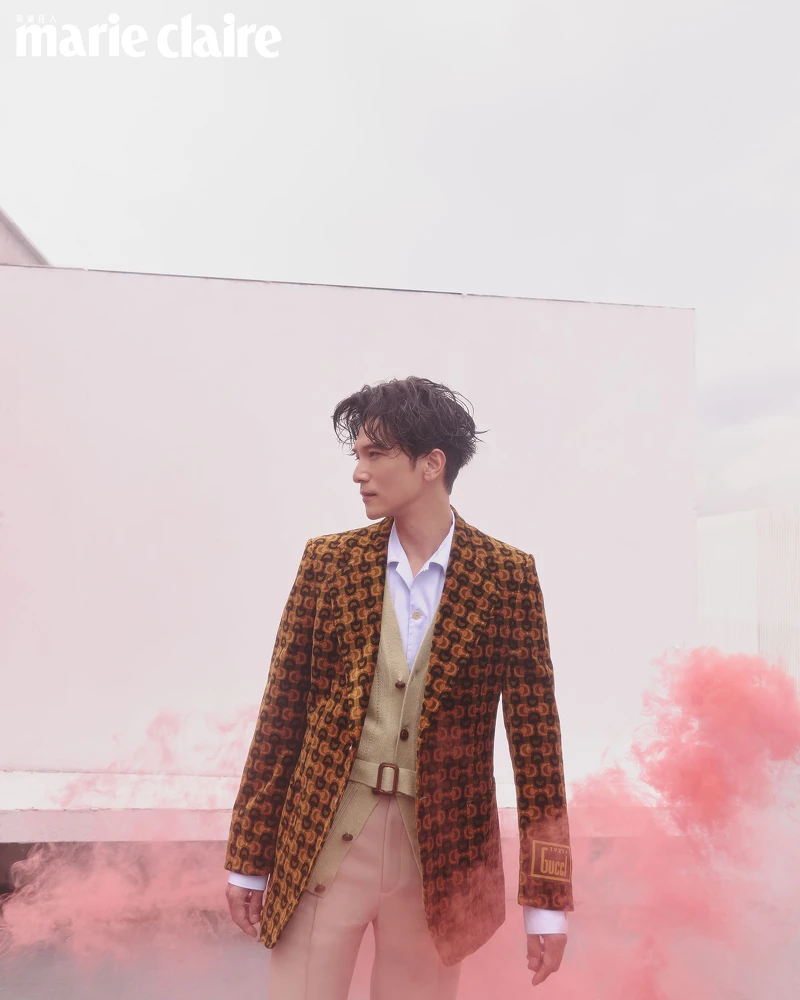 棕色天鵝絨西裝外套、天藍色牛津襯衫、鼠尾草綠腰帶羊毛背心、燕麥色西裝褲，all by Gucci。