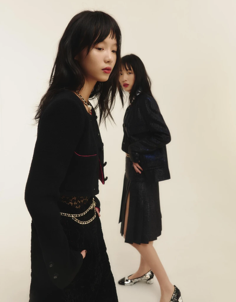 (左)黑色羊毛短版斜紋軟呢外套、黑色蕾絲刺繡內搭、刺繡天鵝絨滑雪造型寬褲、金屬心型造型皮穿鏈腰鍊與項鍊，all by CHANEL。(右)黑色絲質白色領袖口上衣、海軍藍山形紋幻彩丹寧外套與同款開岔及膝裙、銀色亮片雙色低跟芭蕾舞鞋，all by CHANEL。