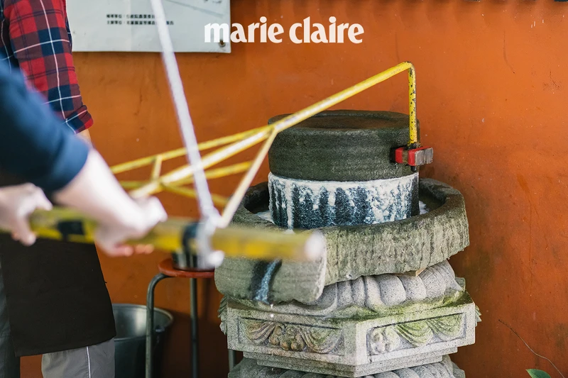 用古老的石磨將黃豆磨成豆漿。