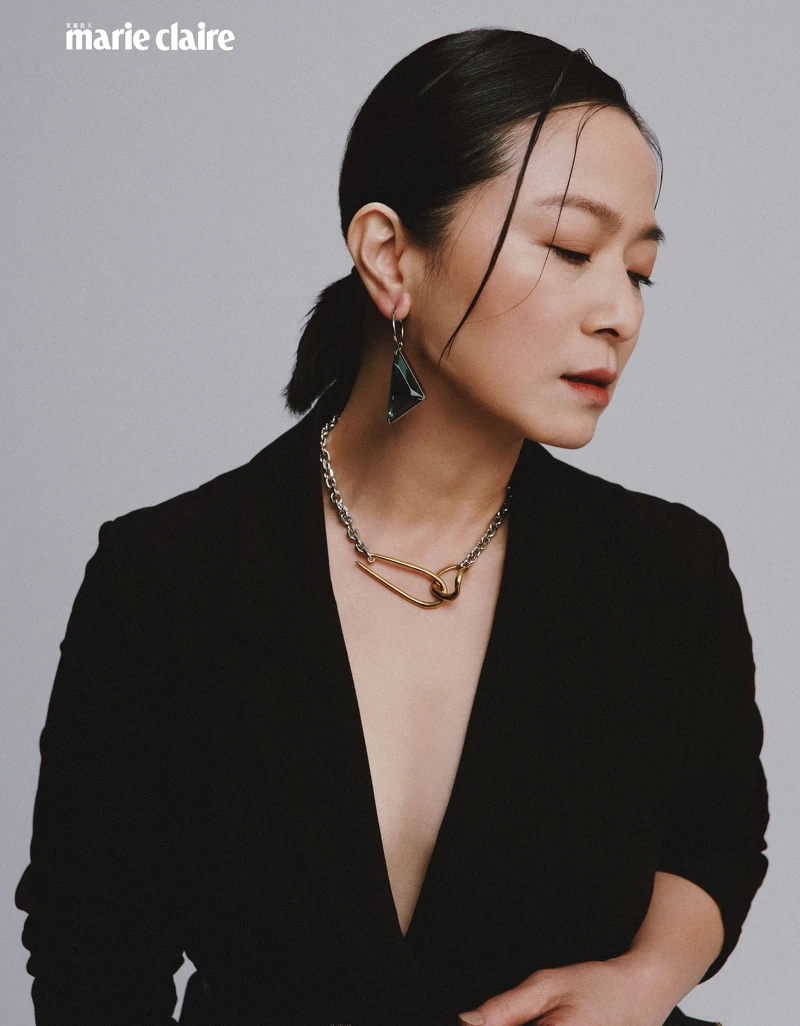 黑色西裝外套、黑色紗裙、黑色窄版皮帶；all by Allsaints；金色項鍊、金色耳骨夾，both by VANN；綠色耳環，Prada。