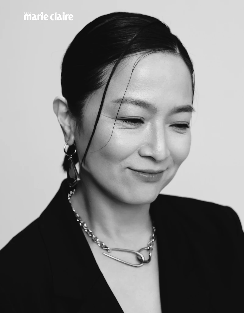 黑色西裝外套、黑色紗裙、黑色窄版皮帶；all by Allsaints；金色項鍊、金色耳骨夾，both by VANN；綠色耳環，Prada。