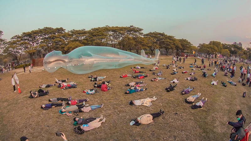 【空氣人】出自日本藝術家鈴木康広之手，目前於衛武營展區「童趣光樂園」草地展出，歡迎遊客每天下午5時30分跟「空氣人」一起躺在草地上，仰望天空，也從另個角度欣賞台灣燈會。