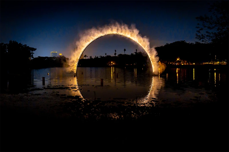 【Arc Zero Eclipse 弧 零：月食】利用水中倒影創造一個完整且對稱的圓形霧環，夜間像火一樣的發光，此作品將永久設置於高雄。（地點：衛武營北湖）