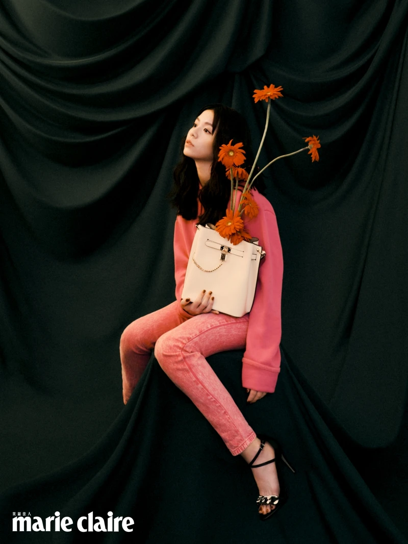 白色Hamilton Legacy香檳包、粉色短版連帽上衣、粉色牛仔長褲、金屬鍊裝飾高跟涼鞋，all by MICHAEL Michael Kors。