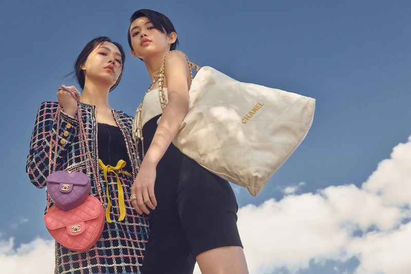 左:黑色彩色格紋斜紋軟呢外套與同款半身裙、黑色上衣、黃色腰帶、粉紫&粉紅愛心形包,All by CHANEL。右:黑白Jersey連身泳衣、CHANEL 22包、服飾珠寶配件,All by CHANEL。 左:黑色彩色格紋斜紋軟呢外套與同款半身裙、黑色上衣、黃色腰帶、粉紫&粉紅愛心形包,All by CHANEL。右:黑白Jersey連身泳衣、CHANEL 22包、服飾珠寶配件,All by CHANEL。