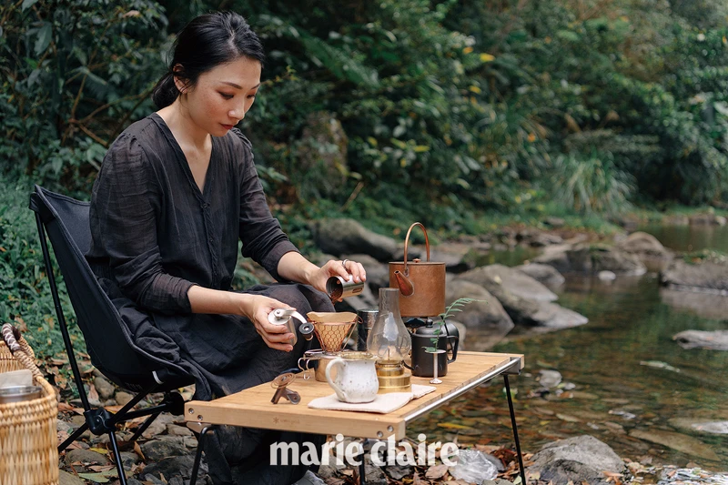 對於戶外環境感到相當自在，熟練的攤開桌面，流暢的擺設道具，接著慢條斯理的泡上一杯咖啡。