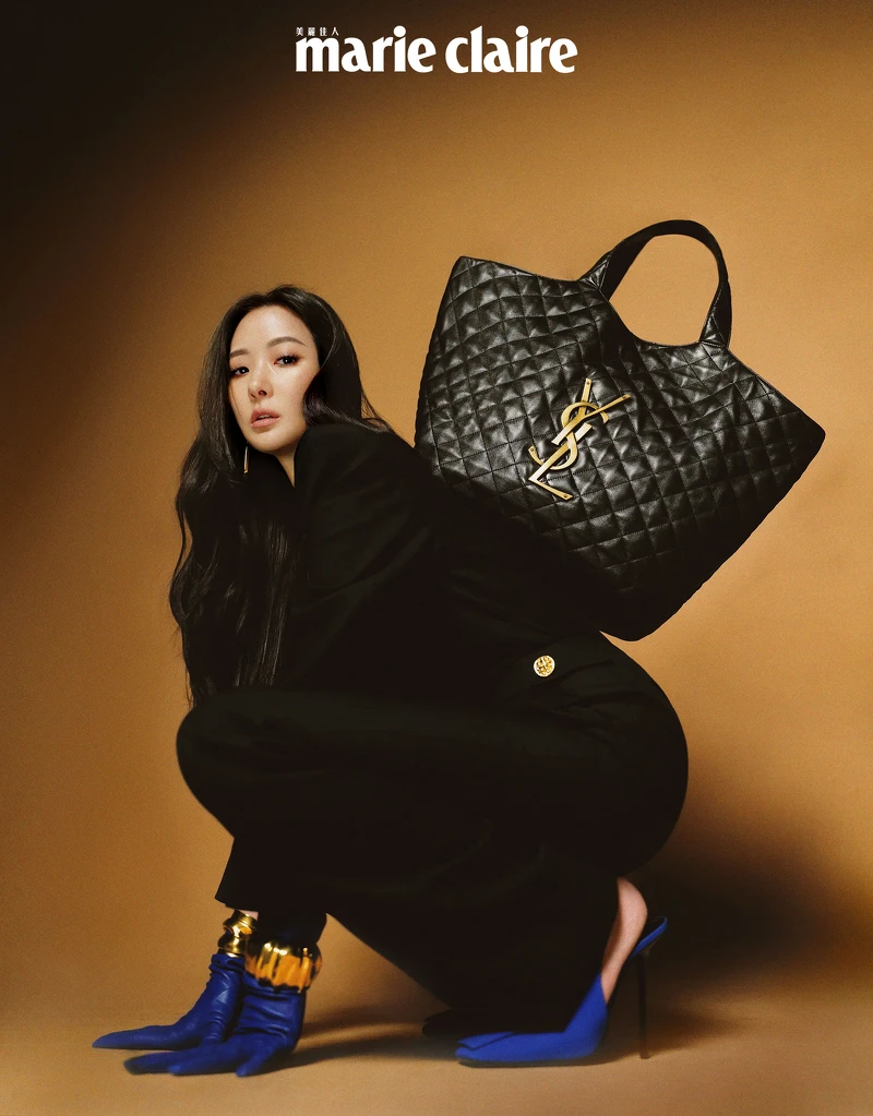 黑色西裝連身服、藍色皮質手套、金色手環、藍色高跟鞋,黑色皮質手提包,all by Saint Laurent。 黑色西裝連身服、藍色皮質手套、金色手環、藍色高跟鞋,黑色皮質手提包,all by Saint Laurent。