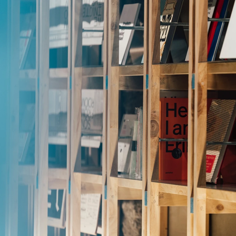 用角料以結構方式堆疊而成的書架，藍色斷面塗漆是角料上原有的防腐區分標記，在角料被木作師傅裁鋸前夕，葉忠宜與張軒豪緊急喊停，以保留材料最原始的樣貌，書店 logomark的藍色幾何 也由此而來。