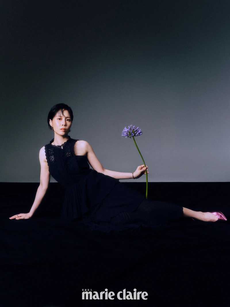 深藍色紗裙洋裝，self-portrait；琥珀色寶石手環、琥珀色寶石戒指、琥珀色耳墜、調色盤戒指，all by Les Néréides；金屬粉色高跟鞋，Christian Louboutin。