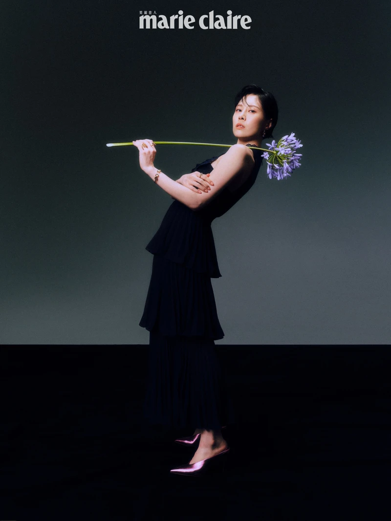 深藍色紗裙洋裝，self-portrait；琥珀色寶石手環、琥珀色寶石戒指、琥珀色耳墜、調色盤戒指，all by Les Néréides；金屬粉色高跟鞋，Christian Louboutin。