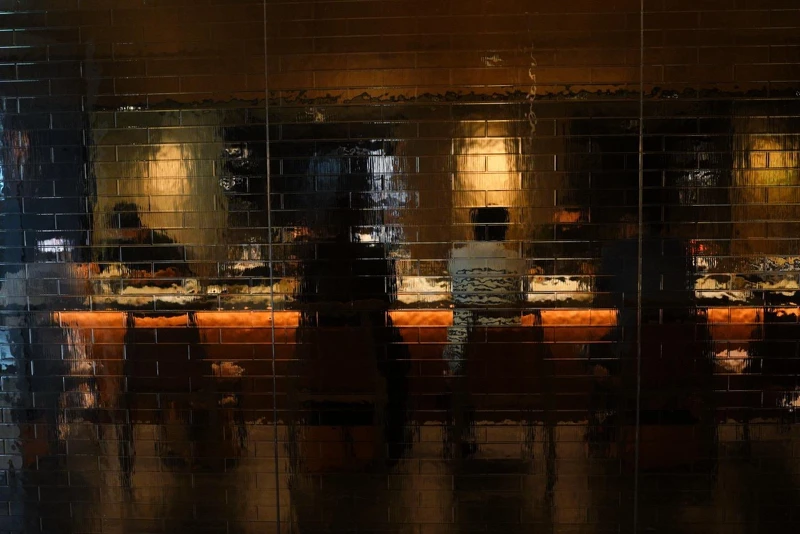 空間中手工訂製的⽔波磚紋玻璃透出隱約的光影相當迷人。