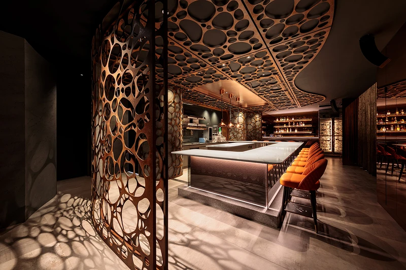 空間以岩石孔洞意象貫穿全場，使用金屬鏽蝕鐵板，質地透出沈沈的礦橘色，呈現洞穴般幽暗隱密感。