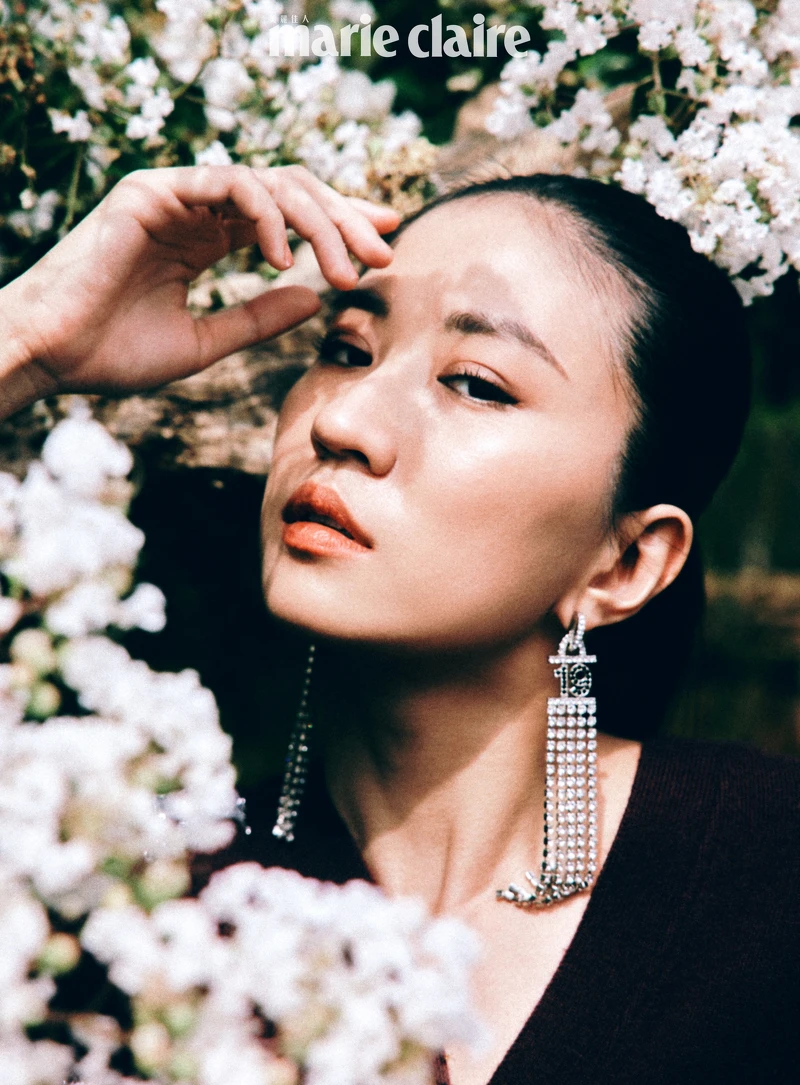 酒紅色刺繡圖紋針織衫、長耳環，both by Chanel。