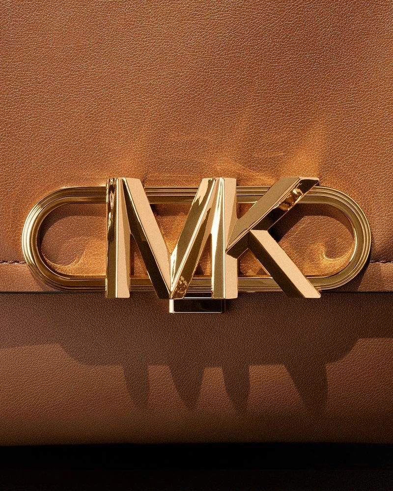 以裝飾藝術風格演繹而生的的MK Empire logo，MK外圍橢圓一圈一圈的溝槽設計，賦予其更細膩的華麗視覺效果。