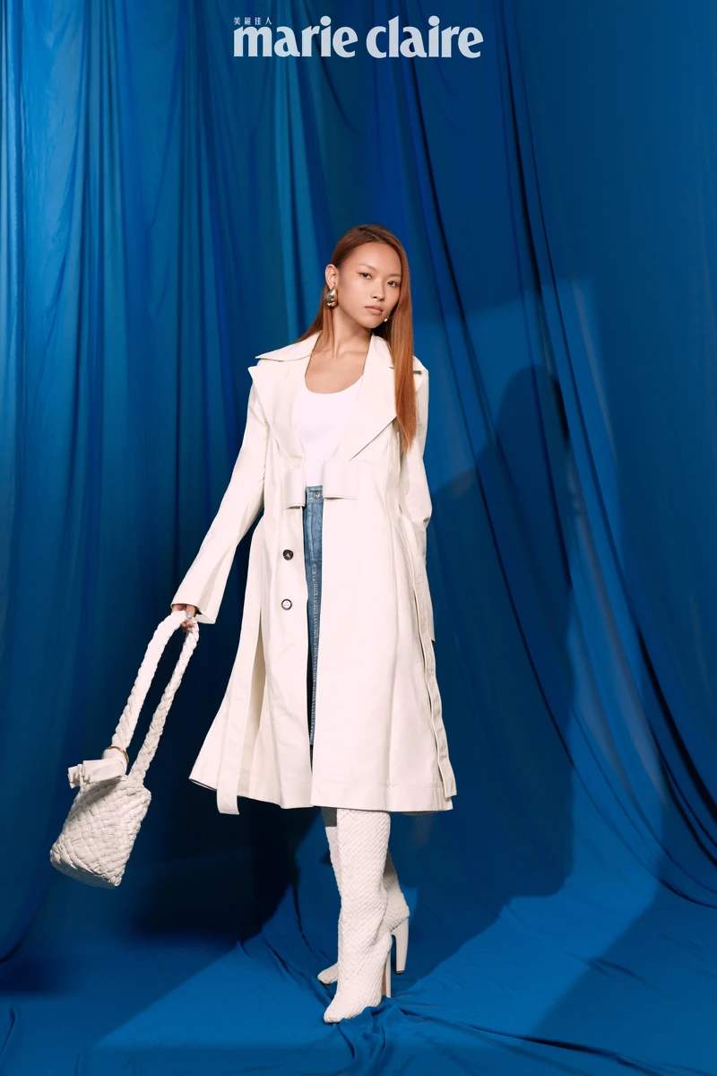 白色皮革風衣、白色背心、皮革丹寧短裙、白色編織高跟長靴、白色編織牛皮肩背包、耳環；all by Bottega Veneta。