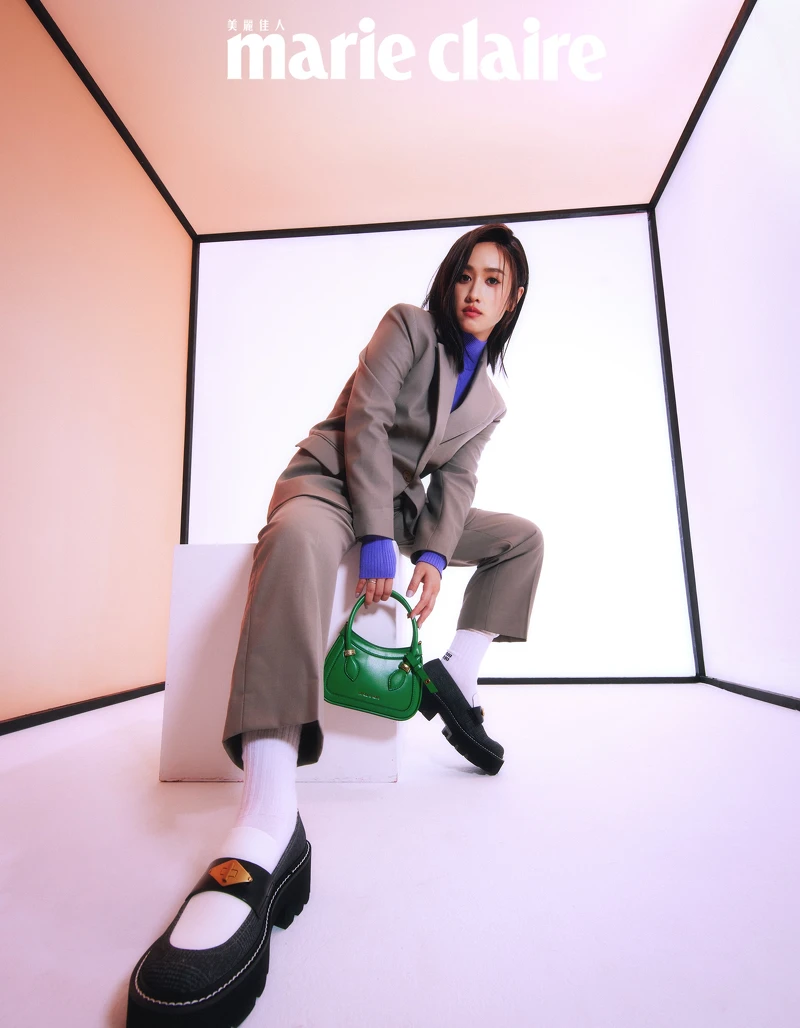 灰綠色西裝外套、灰綠色西裝長褲,both by Sandro;紫色高領針織衫,Maje; 白色長襪,Miu Miu;黑白格紋樂福鞋、綠色手提小包,both by CHARLES & KEITH。 灰綠色西裝外套、灰綠色西裝長褲,both by Sandro;紫色高領針織衫,Maje; 白色長襪,Miu Miu;黑白格紋樂福鞋、綠色手提小包,both by CHARLES & KEITH。