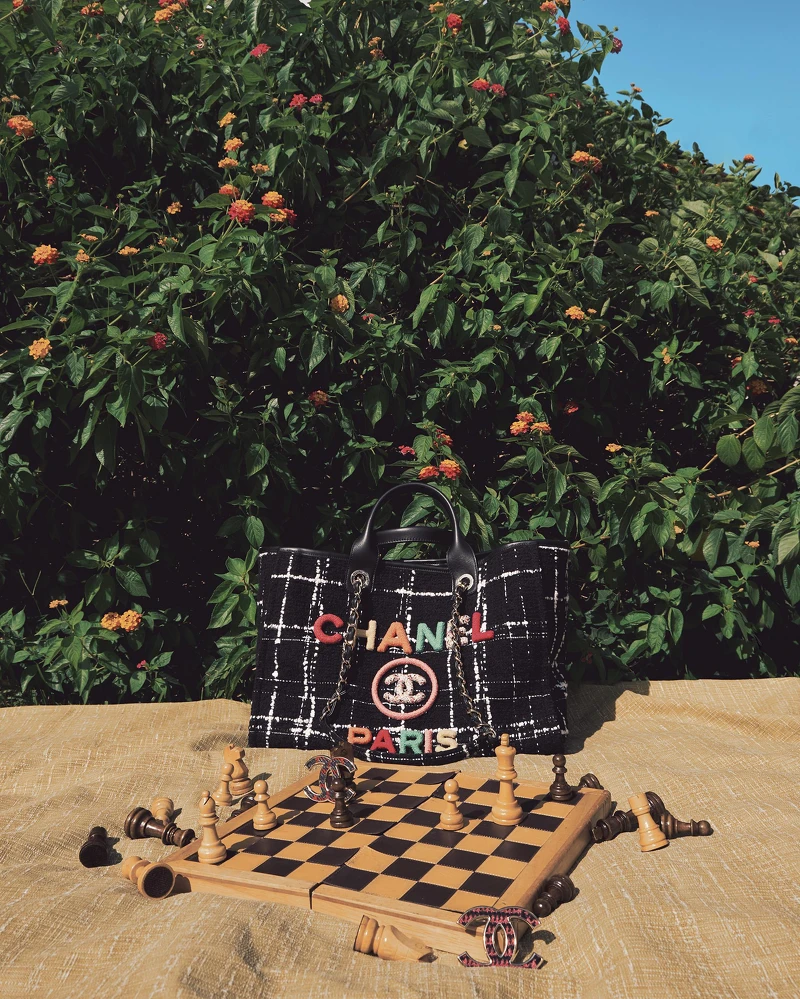 黑色斜紋軟呢購物包、斜紋軟呢胸針，both by CHANEL。