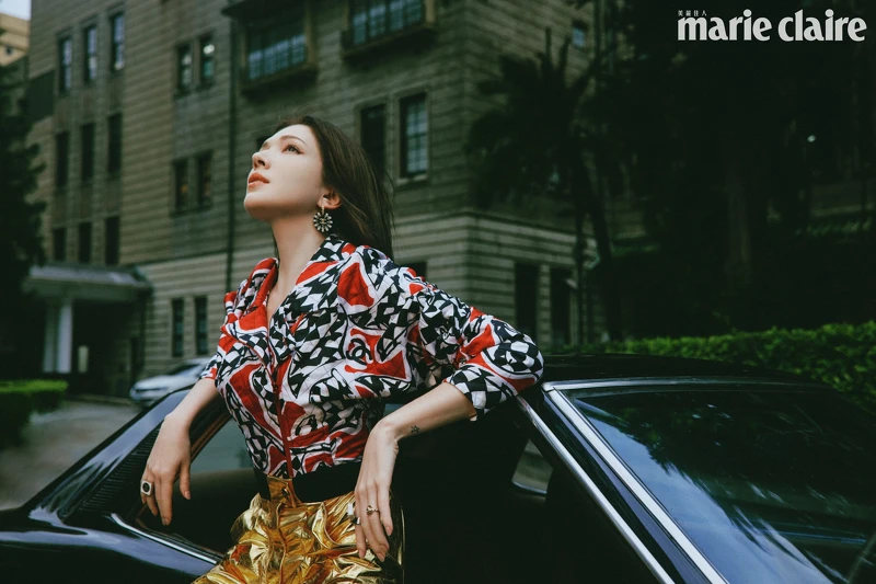 賽車旗幟印花外套、金色皮褲、服飾珠寶耳環與戒指，all by CHANEL。