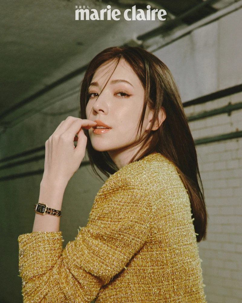 網紗上衣、虹彩光澤金色斜紋軟呢外套、服飾珠寶戒指，all by CHANEL。Première 腕錶-原創款，18K 黃金鍍精鋼錶殼、錶冠及錶鍊。黑色漆面錶盤，鑲嵌凸圓形縞瑪瑙及搭配黑色皮穿鍊錶帶。高精準度石英機芯。功能：時、分顯示，CHANEL。