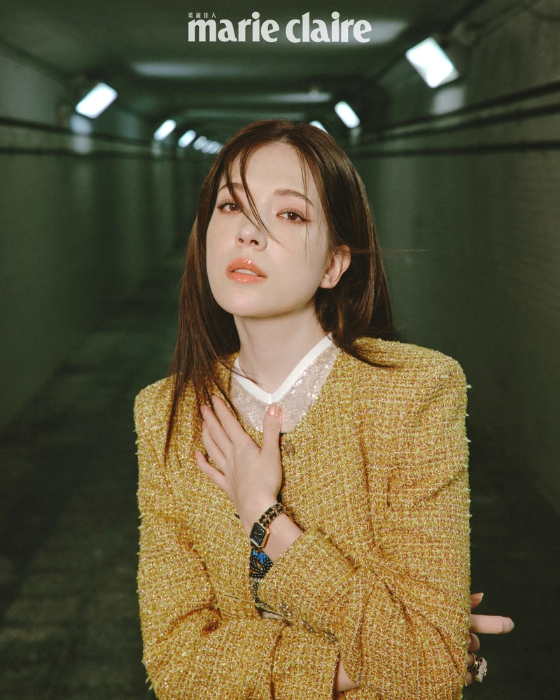 網紗上衣、虹彩光澤金色斜紋軟呢外套、服飾珠寶戒指，all by CHANEL。Première腕錶-原創款，18K 黃金鍍精鋼錶殼、錶冠及錶鍊。黑色漆面錶盤，鑲嵌凸圓形縞瑪瑙及搭配黑色皮穿鍊錶帶。高精準度石英機芯。功能：時、分顯示，CHANEL。