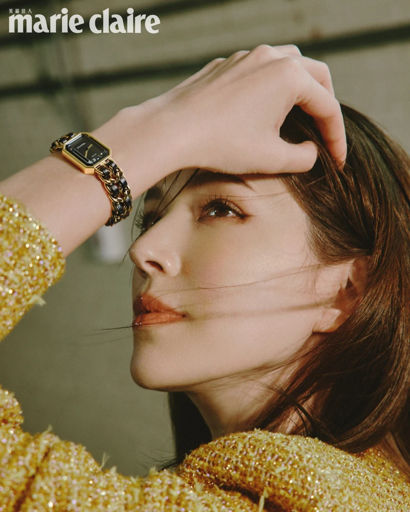 虹彩光澤金色斜紋軟呢外套、服飾珠寶戒指，all by CHANEL。Première腕錶-原創款，18K 黃金鍍精鋼錶殼、錶冠及錶鍊。黑色漆面錶盤，鑲嵌凸圓形縞瑪瑙及搭配黑色皮穿鍊錶帶。高精準度石英機芯。功能：時、分顯示，CHANEL。