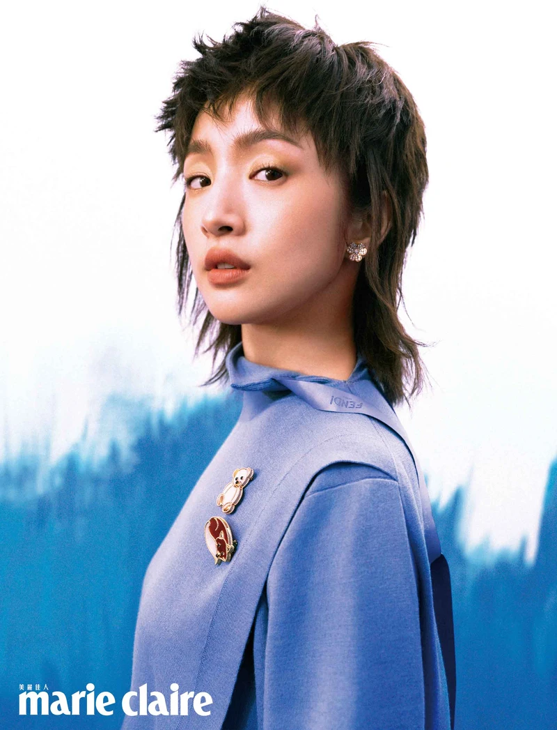 藍色高領針織衫， Fendi。 18K玫瑰金鑲鑽 Frivole 迷你款耳環、珍珠母貝及縞瑪瑙鑲嵌的18K 玫瑰金 Lucky Animals Teddy Bear 胸針、珍珠母貝、紅玉髓及縞瑪瑙鑲嵌的18K黃金 Lucky Animals Fox 胸針，all by Van Cleef & Arpels。