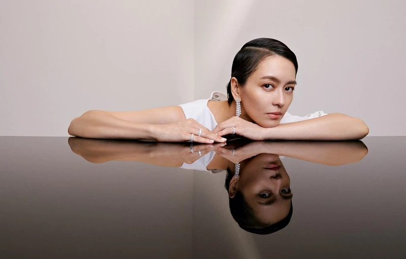 白色洋裝、平底麂皮長筒靴HERMES 流蘇梨形鑽耳環、雷地恩永恆鑽戒SHEE’S FINE JEWELRY