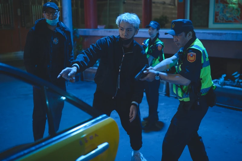 金獎導演黃信堯（右）在《黑的教育》飾演警察，導演柯震東和他現場講戲