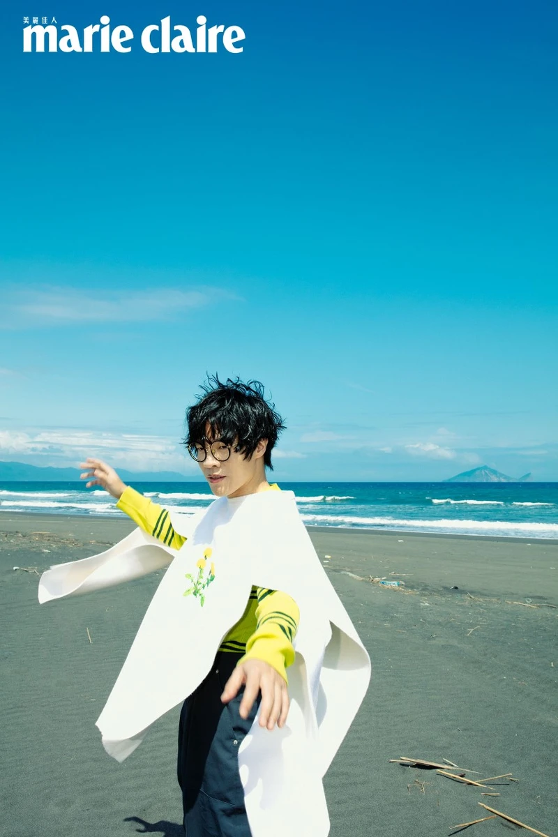 鮮黃色羊毛條紋上衣，Prada；雛菊刺繡圖案斗篷式上衣、藍灰色長褲、羔羊毛緄邊拖鞋，all by Loewe。