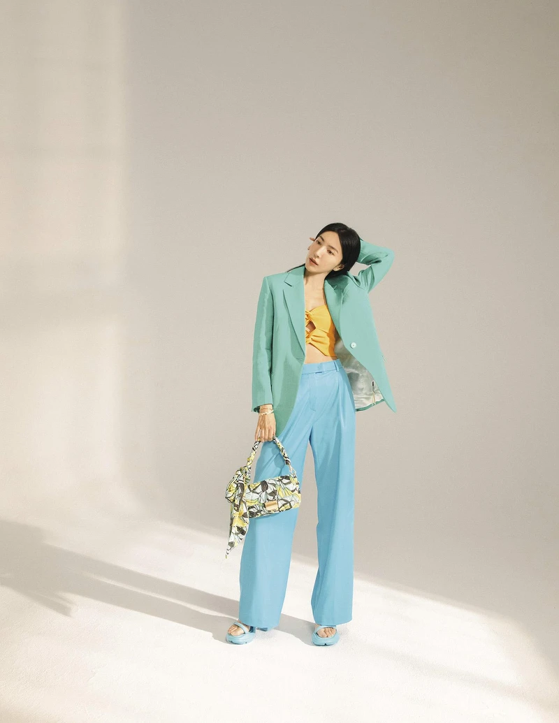 橘色針織小背心、藍綠色西裝外套，both by Sandro；水藍色西裝長褲，MAX&Co.；印花手拿包，水藍色綁帶跟鞋，both by CHARLES & KEITH；Tiffany True 戒指、Tiffany HardWear 球形戒指、Tiffany T Wire 線圈手鏈、Tiffany T1 手環、鋪鑲鑽石手環，all by Tiffany & Co.。